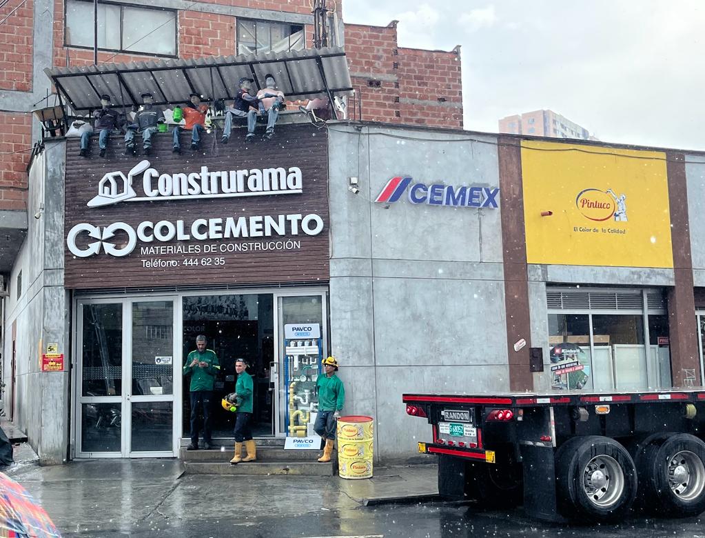 Fachada de Colcemento en El Poblado, Medellín, con avisos Construrama, Cemex y Pintuco